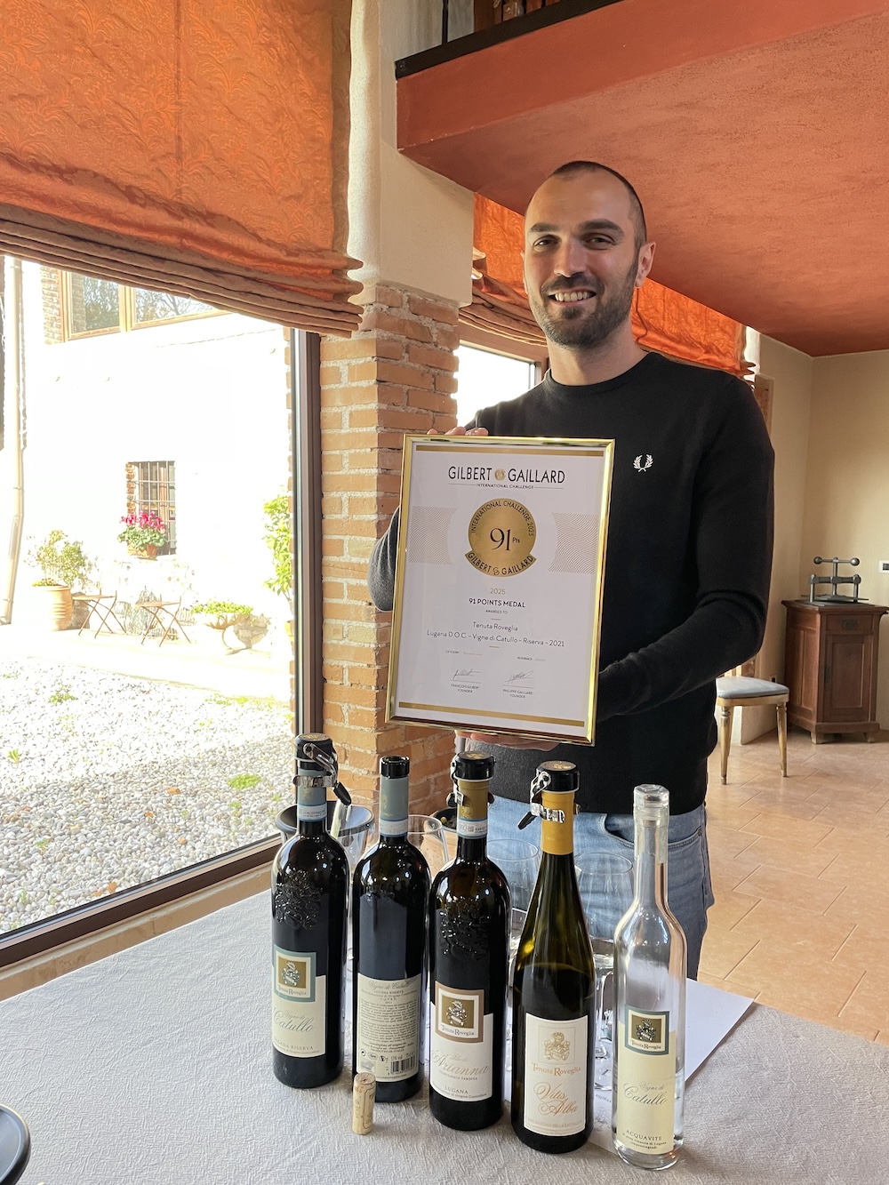 Leonardo, responsable de l&rsquo;accueil, pose fi&egrave;rement avec les vins et le dipl&ocirc;me obtenu au Gilbert & Gaillard International Challenge