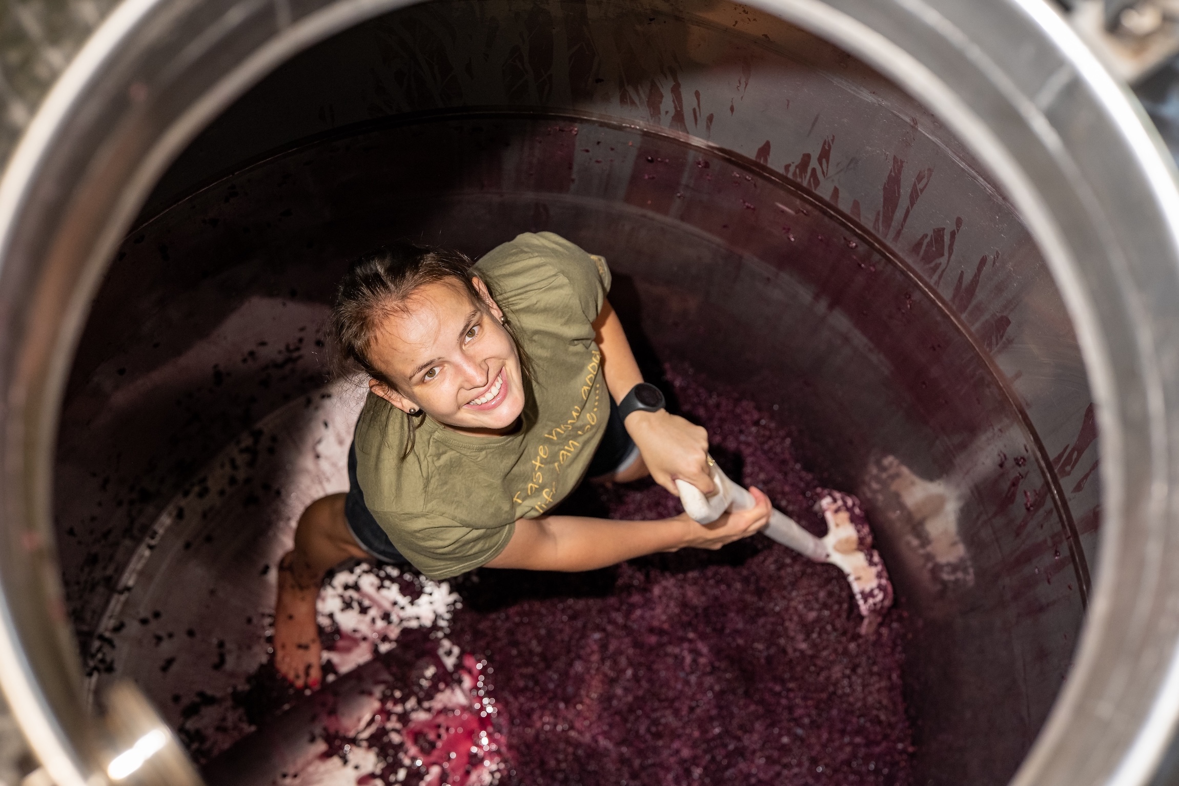 Winemaker Jamie Papenfus punching down grapes during harvest at Waterford Estate